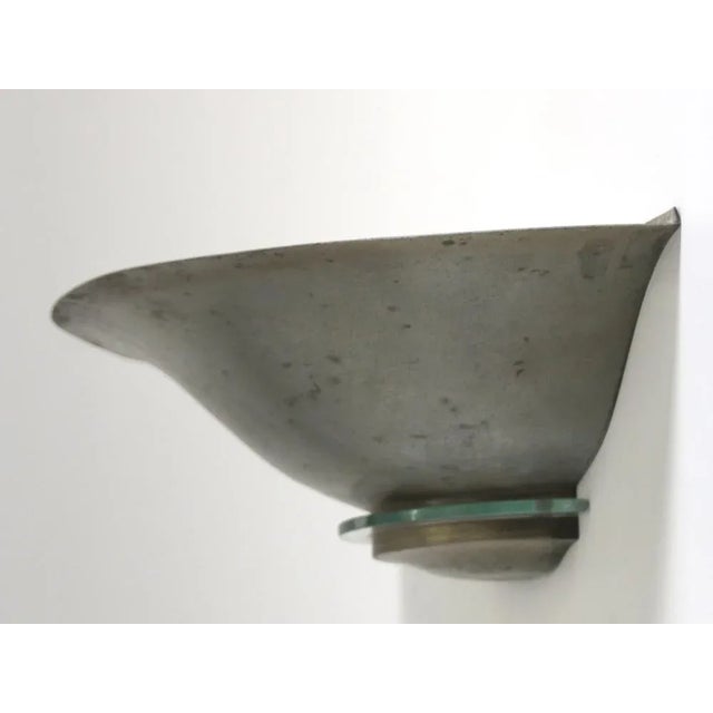 This wall lamp was designed and produced in the 1940s in France. The half-shell of nickeled metal holds a small piece of...