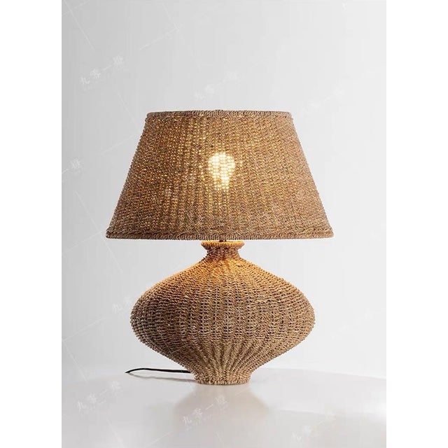 This lamp is entirely handcrafted from woven rattan, featuring a unique, tapered body (with distinct textures) and a fan-...