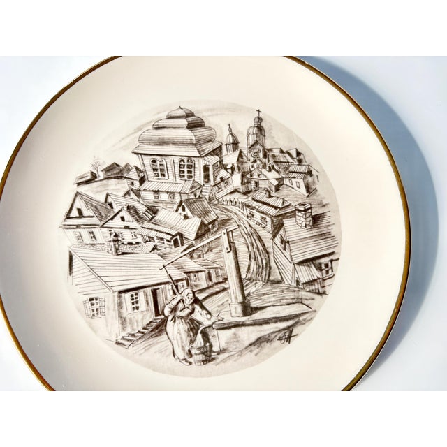 This collectible vintage decorative plate showcases “THE SHTETL,” an iconic image by acclaimed artist Oscar Harris,...