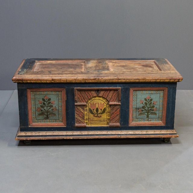 A colorful antique E. European pine blanket chest with hand painted floral motif. The top typically has the most wear -...