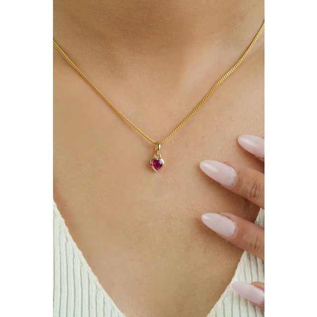 This heart pendant features a 0.56 carat natural heart-cut ruby, set in 14K Solid Yellow Gold. The ruby measuring...