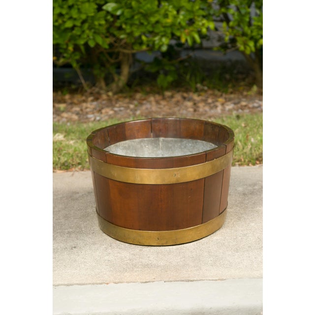 An English oval oak planter from the late 19th century with brass braces and liner. Used as a wine cooler or a planter,...