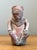 This evocative Pre-Columbian style seated figure is a masterful example of primitive clay sculpture, capturing the...