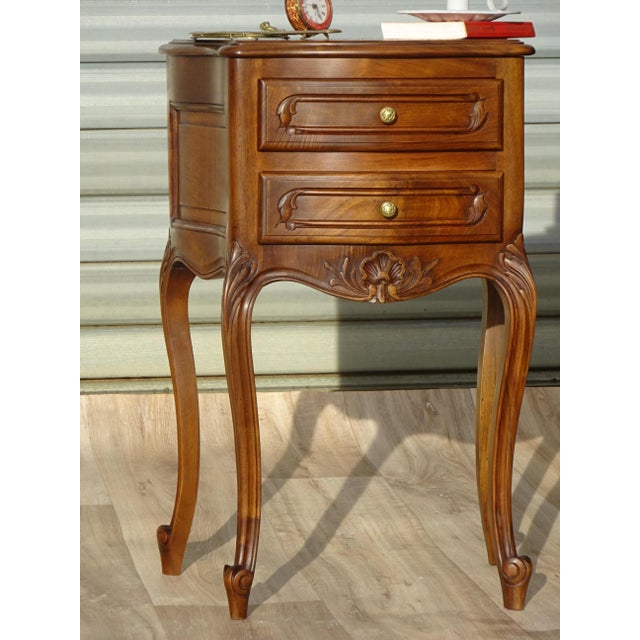 Small bedside table in solid walnut in the Louis XV style. The front and sides are curved. The top has semi-rounded edges...