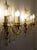 A pair of Florentine sconces in iron, gilded wood, and crystal, crafted in the mid-20th century. The three-light structure...
