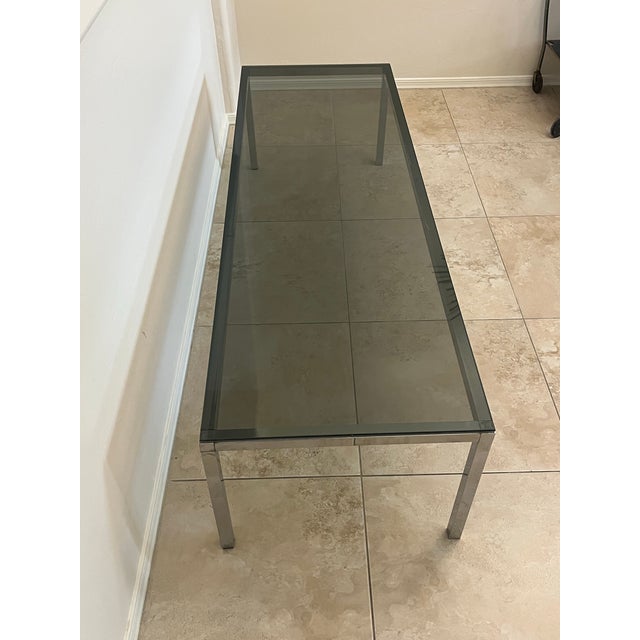 Amazing Mid-Century Modern rectangular glass coffee table, featuring a polished chrome steel frame and a dark smoked glass...