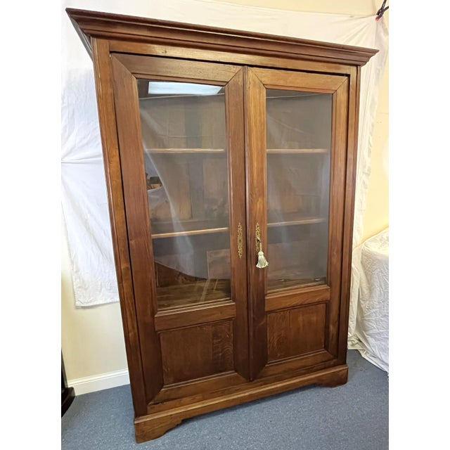 Such a rare antique find in such good condition! The 19th century glass front cabinet is beautifully made of a rich honey...