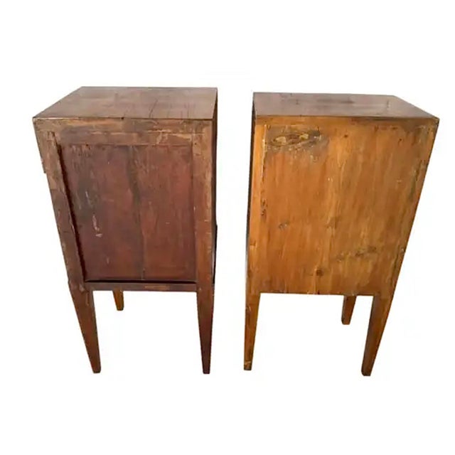 Elegant Pair of Italian Neoclassical Bedside Cabinets crafted in walnut with part-ebonized column accents. Each cabinet is...