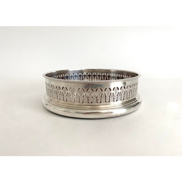 English Barker-Ellis silver-plated wine coaster featuring a pierced border with engraved design and rope twist rim. Wood...