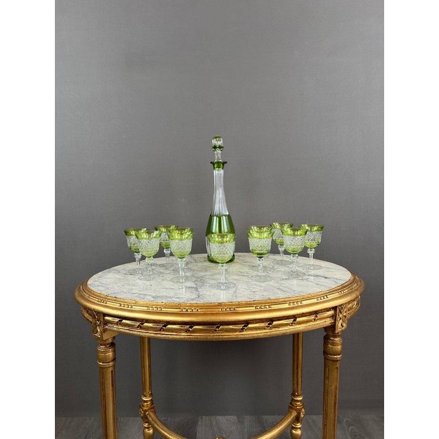 Set of 11 green-tinted crystal glasses and a matching decanter, 20th century. We present an exquisite tableware set, ideal...