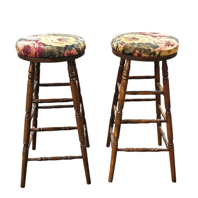 A pair of mid 20th Century turned, stained walnut and Upholstered bar stools. Measure 15.5" in width, 15.5" in depth and...