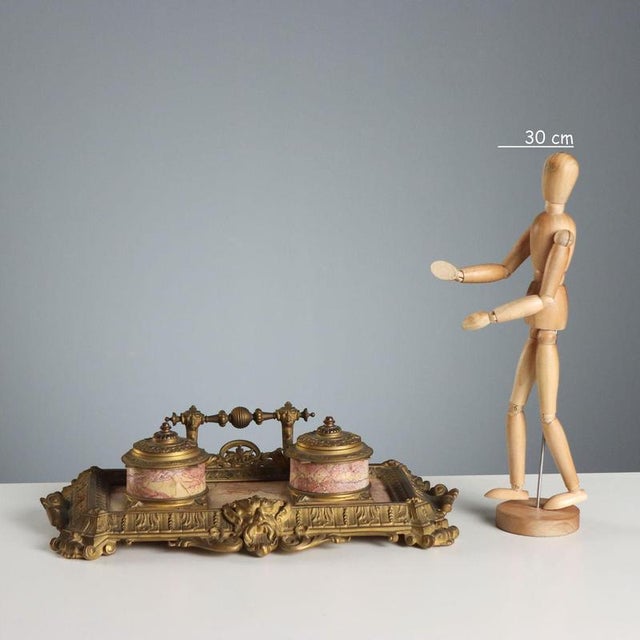 Double bronze inkwell chiseled with leafy scrolls and a mascaron on the front. Base and vial holder in pink marble. Ink...