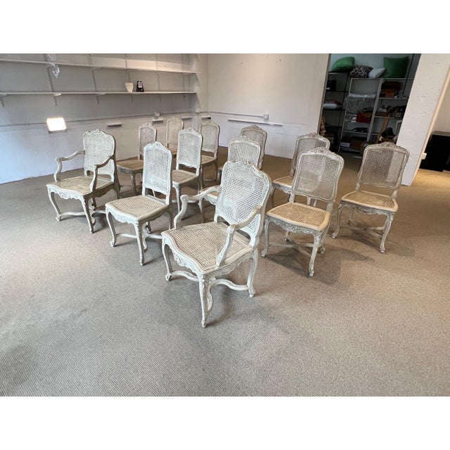 A Set of 12 Caned & Painted Régence Style Chairs, 2 Arm 10 Side All surfaces in good condition New seats, Chairs tight &...