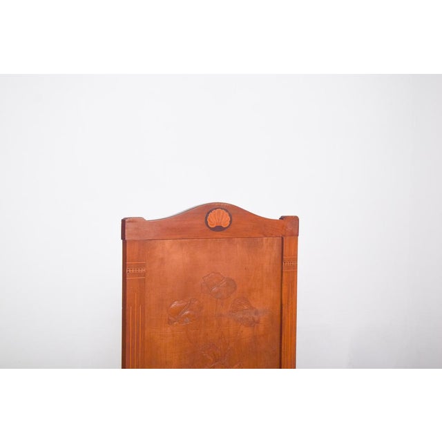 This fireplace protector is made of carved wood.