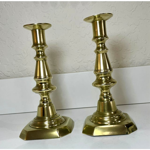 A pair of vintage 19th century English brass candlestick holders showcasing classic English craftsmanship. The pair are...