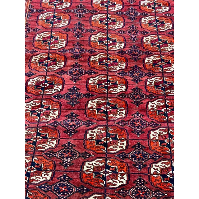 Vintage Afghan Turkmen Bokhara rug, hand-knotted in Afghanistan from 100% wool. Measuring 5’3” x 7’11”, the rug features a...