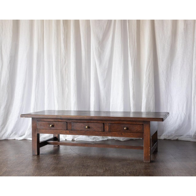 This late 1800s Belgian dark wood coffee table features a beautifully simple silhouette with three front drawers for...