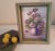 This beautiful purple floral painting features an arrangement of flowers in a vase. It is signed by the artist and comes...
