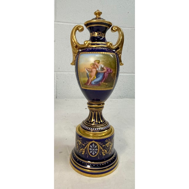 This Antique hand painted Royal Vienna porcelain cobalt and gold lidded urn is a stunning piece from the Victorian era,...