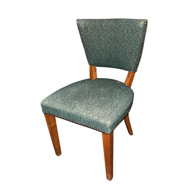 This vintage mid-century modern side chair features a green textured tweed upholstery accented with brass nailhead trim on...