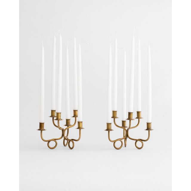A pair of petite, six-arm brass candelabra by pioneering Austrian-Swedish architect and designer Josef Frank for Firma...