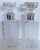 Matching pair of heavy crystal cut decanters with matching stoppers each fashioned with a swirling pattern and sterling...