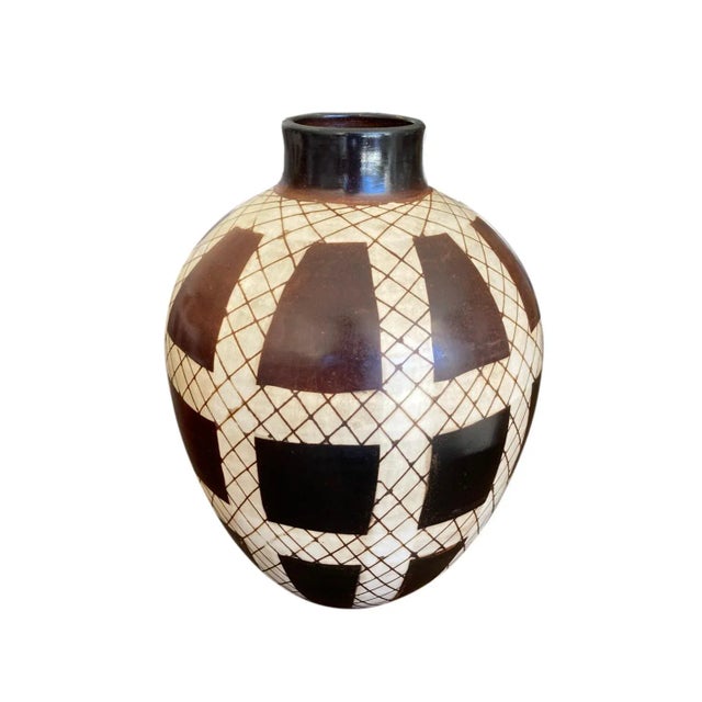 A handmade studio pottery vase made in Chulucanas, Peru by ceramic artist Jose Sosa. The brown and cream glaze with a net...