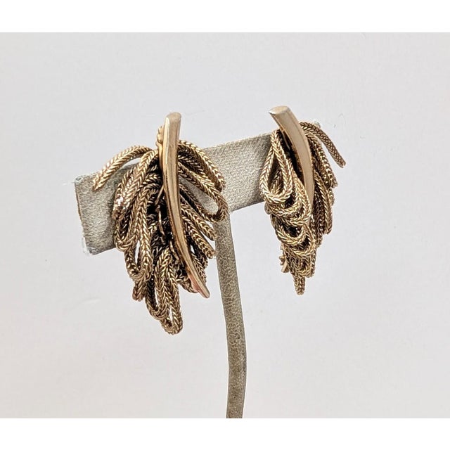 1950s goldtone smooth center with mesh loops "leaves" clip earrings. Marked "NAPIER" in the dip of the clips. Measure: 1...