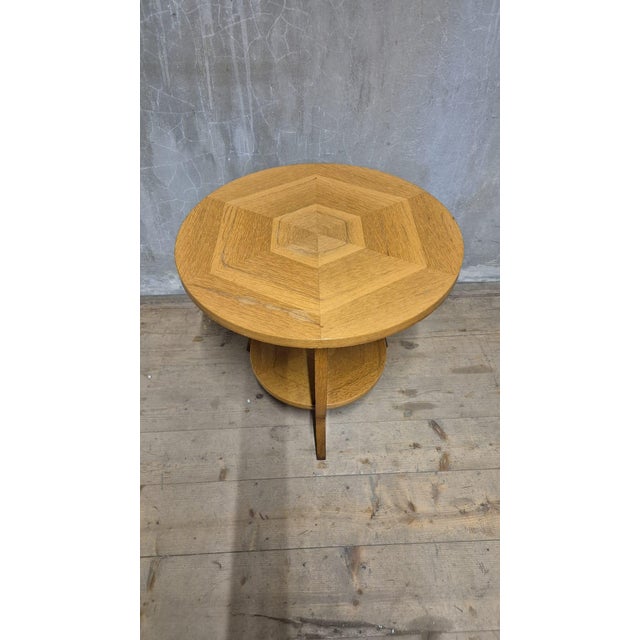A charming vintage wooden coffee table featuring a round tabletop, a sculptural curved-leg base, and a circular lower...