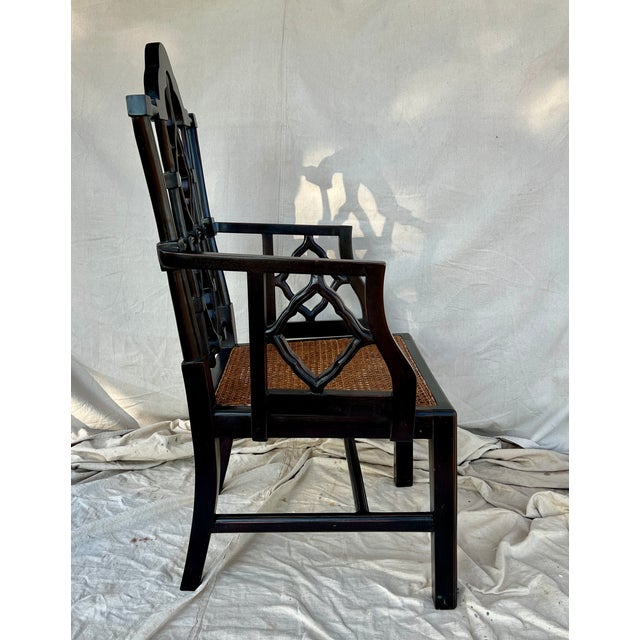 A Chinese Chippendale style ebonized armchair with a double hand caned seat. Hand carved frame of Philippine mahogany with...