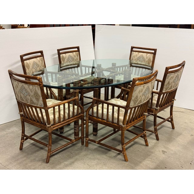Design Plus Gallery presents a Vintage Dining Set from McGuire Furniture. The table pairs an oval beveled glass top with a...