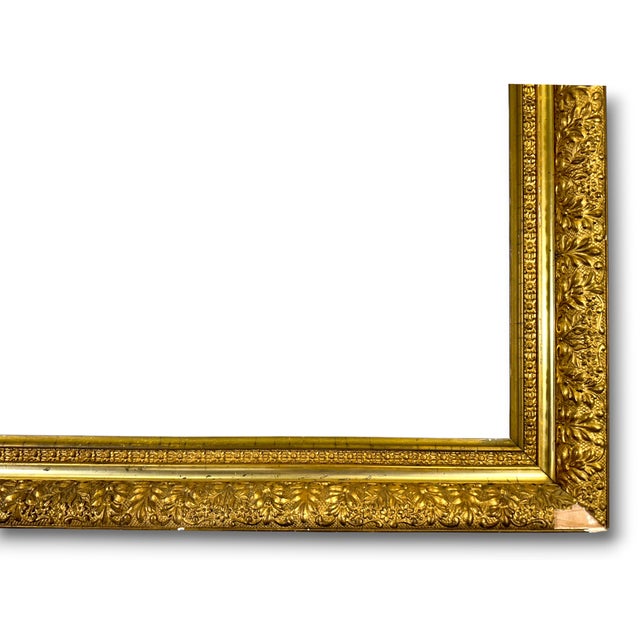 An antique giltwood picture frame constructed of wood and gesso. Ornate details. Age is estimated to be early 20th...