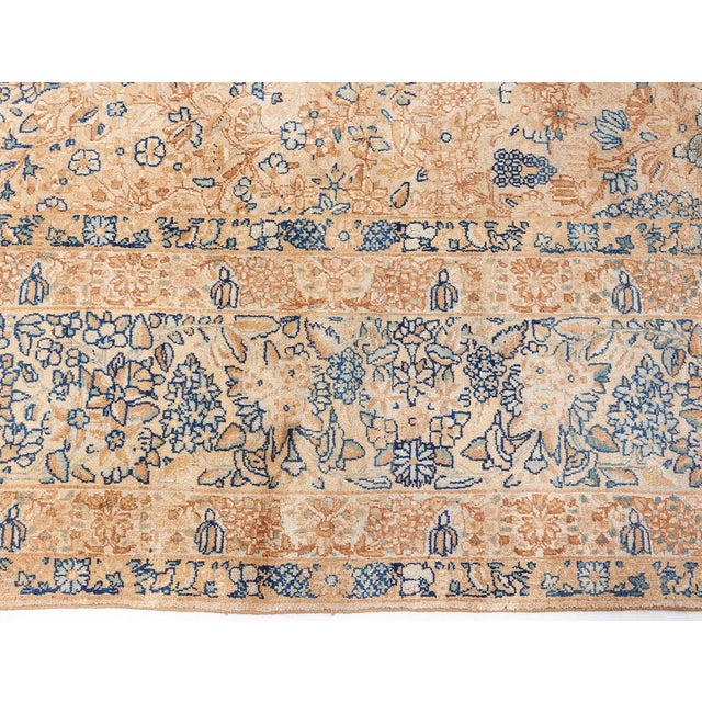 This Persian Kirman (Kerman) antique rug, was made in the late 19th century. Its caramel main field carries a finely-woven...