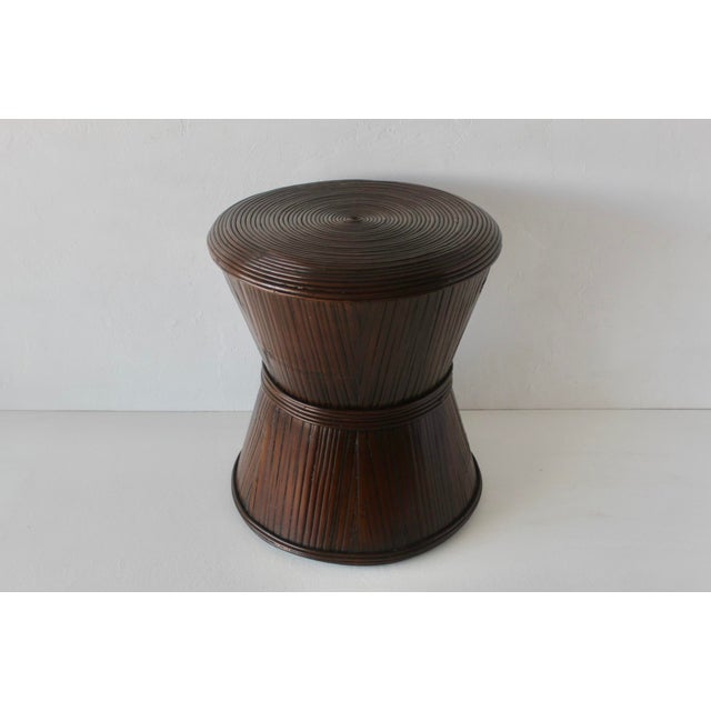 Sculptural bamboo pedestal side table featuring an hourglass bowtie shape, vertically bamboo reeds, cinched at the center,...
