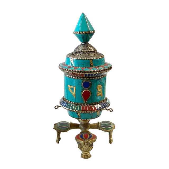 A prayer wheel' is a cylindrical wheel on a spindle made from brass metal, turquoise and coral stones, lapis lazuli and...