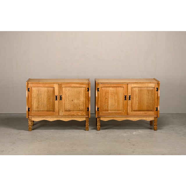 A pair of cabinets attributed to Henning Kjærnulf, Denmark, 1960s. Crafted from richly figured veneered and solid oak....