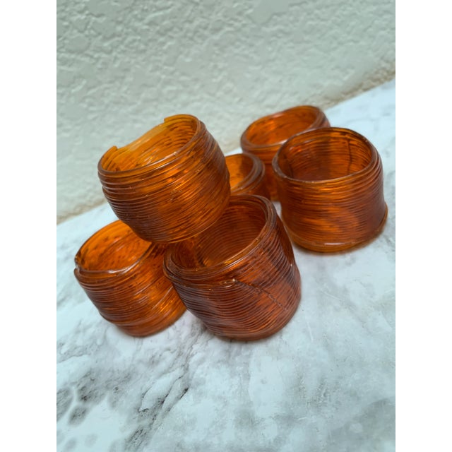 Vintage set of six honey toned, amber orange ribbon style napkin rings. Texture design that looks like wrapped ribbons or...