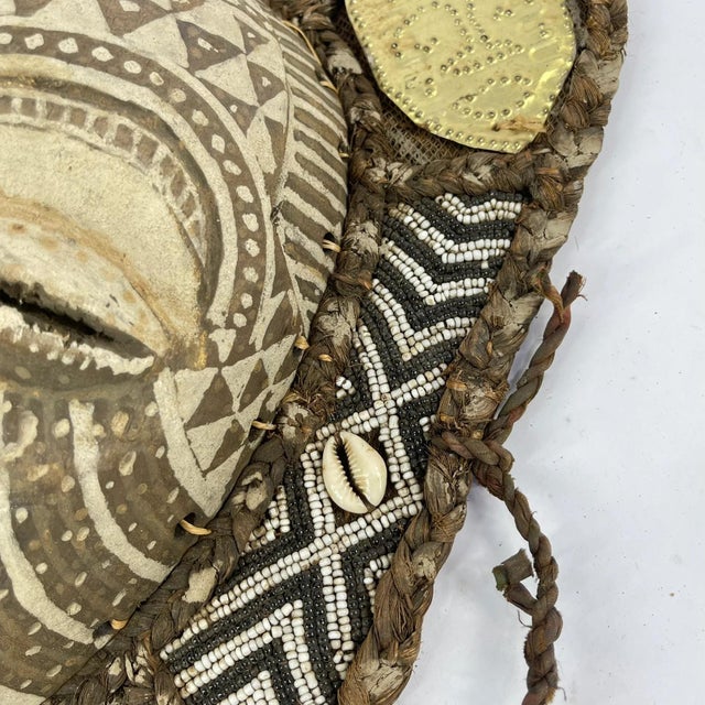 A beautiful face mask with on a beaded plaque, usually hung in a healer's house. Ornate patterns of shells and glass beads...