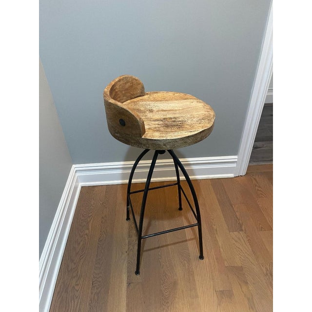 Beautiful set of two swival bar stools featuring hand- carved solid wood seats with a warm , natural finish and low...