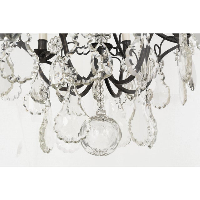 A Louis XV style six-light chandelier with an assortment of crystals with rosettes, including French pendalogues and large...