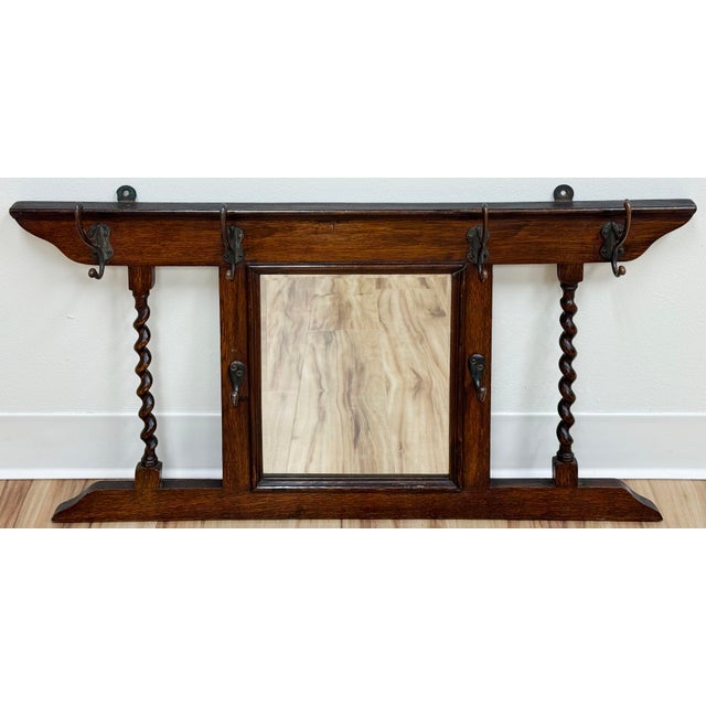 Antique English oak hall tree featuring six (6) double hooks for hanging. Rich deep stain with barley twist accents and...