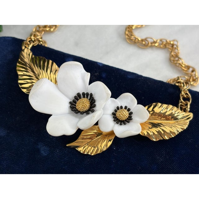Bold and elegant vintage necklace by Louis Feraud, Paris, featuring two large white flowers with black stamens and gold...