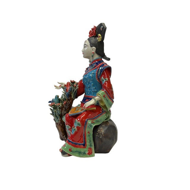 This is a Chinese decorative ceramic pottery figure of an ancient Qing style dressing lady with fine precise fingers and a...