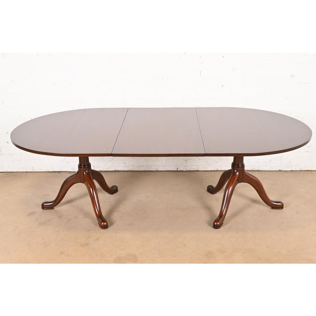 A gorgeous Georgian, Regency, or Queen Anne style solid mahogany double pedestal extension dining table By Kittinger,...