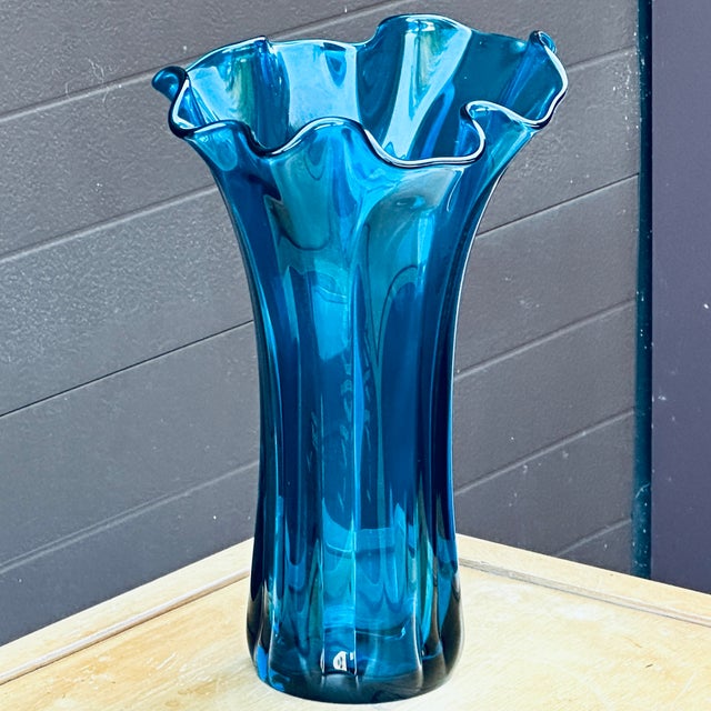 Large vintage blue ruffled rim blown glass vase. The solid blue hue is lighter than cobalt. Measuring roughly 14" tall by...