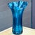Large vintage blue ruffled rim blown glass vase. The solid blue hue is lighter than cobalt. Measuring roughly 14" tall by...