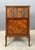 French Louis XVI-style faux-book cabinet with marble top, decorative veneers, marquetry and gilt-metal accents....