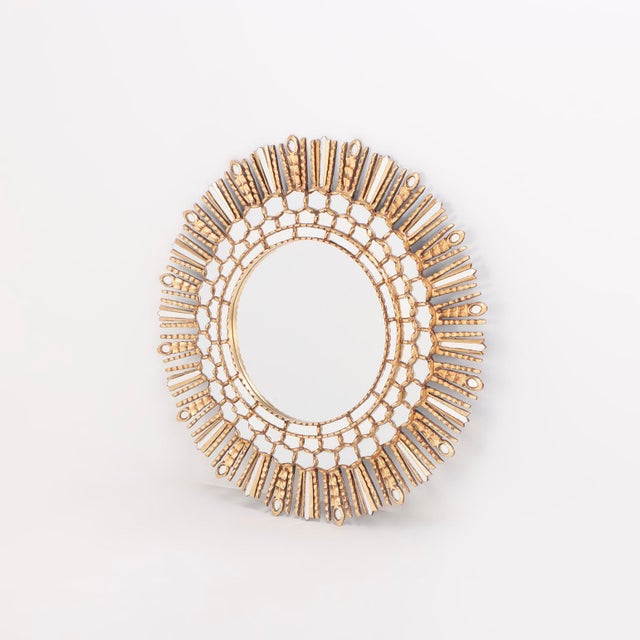 Executed in the iconic radiant form, the mirror features a circular looking glass surrounded by boldly carved rays,...