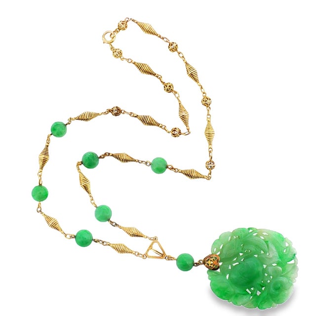 A vintage drop necklace with a carved green jadeite centerpiece featuring a pomagranate. Pomegranates have long symbolized...