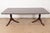 An exceptional Georgian or Regency style double pedestal extension dining table In the manner of Baker Furniture USA,...